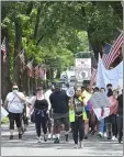  ?? PETE BANNAN - MEDIANEWS GROUP ?? Black Lives Protesters march between the flags along Knowles Avenue in Glenolden Park.
