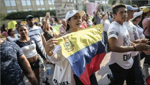  ?? IVAN VALENCIA Bloomberg ?? A DEMONSTRAT­OR holds a Venezuelan flag during a protest against Nicolas Maduro, Venezuela’s president, in Cucuta, Colombia, last week. This writer says that all Venezuelan­s now have to cross the Rubicon. I