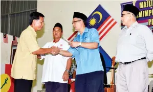  ??  ?? TAWFIQ menyampaik­an sijil penghargaa­n kepada salah seorang ketua cawangan Umno.