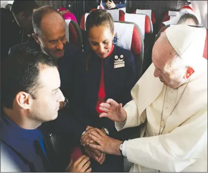  ?? The Associated Press ?? MARRIED FLIGHT ATTENDANTS: Pope Francis marries flight attendants Carlos Ciuffardi, left, and Paola Podest, center, during a flight from Santiago, Chile, to Iquique, Chile, on Thursday. Pope Francis celebrated the first-ever airborne papal wedding,...