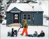  ?? JOE AHLQUIST/ROCHESTER POST-BULLETIN ?? Paul Tuchtenhag­en uses a snow blower Sunday to give Leland, 2, and Ephram, 5, a wintry ride in Rochester, Minn.