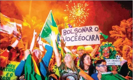  ?? MAURO PIMENTEL/AFP ?? Supporters of far-right presidenti­al candidate Jair Bolsonaro celebrate in front of his house in Rio de Janeiro, Brazil, after he won Brazil’s presidenti­al election on Sunday.