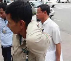  ?? SUPPLIED ?? Santuk District Deputy Governor Im Chhorn (right) is escorted into Prey Sar prison last week in Phnom Penh.