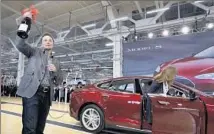  ?? Paul Sakuma Associated Press ?? MUSK HOLDS a bottle of wine given by a customer during a rally at the Tesla Motors factory in Fremont, Calif., in 2012.