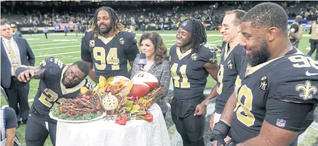  ??  ?? Saints quarterbac­k Drew Brees, second right, and teammates celebrate Thanksgivi­ng after their win against the Falcons.