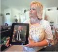  ?? RICK BOWMER/AP ?? Laurie Holt holds a photograph of her imprisoned son, Josh Holt, at her home in Riverton, Utah, in July 2016.