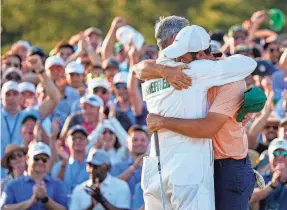  ?? ADAM CAIRNS/USA TODAY NETWORK ?? Scottie Scheffler hugs his caddie, Ted Scott, on the No. 18 green after winning the Masters for a second time.