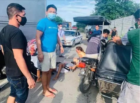  ?? TO THE RESCUE. (Chris Navarro) ?? Arayat Vice Mayor Sixto 'Pogi' Mallari assists a motorcycle rider after figuring in an accident involving a cargo truck in Barangay San Roque, Arayat town last Tuesday. The victim was rushed to the nearest hospital while policemen responded to the scene.