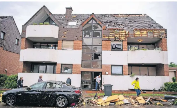  ?? FOTO: LINO MIRGELER/DPA ?? In Paderborn wurden zahlreiche Dächer bei dem Unwetter abgedeckt. Kurz darauf begannen die Aufräumarb­eiten.