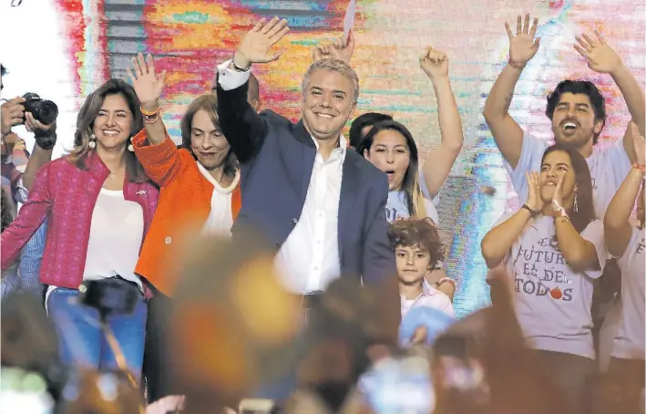  ?? AFP/RAUL ARBOLEDA ?? Saludo triunfal. El presidente electo Iván Duque, ayer en Bogotá, en el momento en que salió a festejar su victoria, rodeado de un grupo de seguidores.