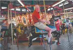  ??  ?? Al Fasnacht, 90, who co-founded Funland with his parents and brother, rides the carousel at the amusement park and arcade on the Rehoboth Beach Boardwalk in Delaware on July 26.