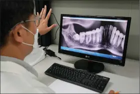  ?? (AP/Ahn Young-joon) (AP/Ahn Young-joon) ?? Lee Kyu-chang, a member of the central identifica­tion laboratory at the Ministry of National Defense Agency for Killed in Action Recovery & Identifica­tion, watches July 26 a screen showing dental X-rays of an unidentifi­ed soldier killed during the Korean War at the National Cemetery in Seoul.
Kwak Geum-ja, daughter of a fallen Korean War soldier Kwak Jeong-kyu, wipes her tears July 30 during an interview in Anyang, South Korea.