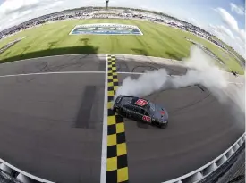  ?? (Sean Gardner/getty Images) ?? Kurt Busch, driver of the #45 Jordan Brand Toyota, celebrates with a burnout after winning the Cup Series Adventheal­th 400 at Kansas Speedway Sunday.