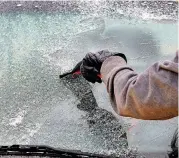  ?? [PHOTO BY JIM BECKEL, THE OKLAHOMAN] ?? Right: Linda Lane scrapes ice from her car’s windshield in Midwest City on Tuesday morning.