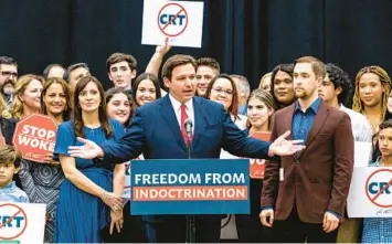  ?? DANIEL A. VARELA/AP ?? Gov. Ron DeSantis addresses the crowd before publicly signing the “individual freedom,”“stop woke” legislatio­n on April 22, 2022. Looking on is Christophe­r Rufo, right, appointed in January by DeSantis to the New College Board of Trustees with a mission to reshape the public college.