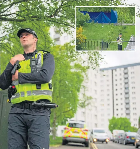  ??  ?? A police officer stationed outside Hilltown Court. Inset: A blue tarpaulin tent near the multi.