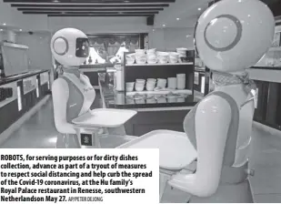  ?? Ap/peter Dejong ?? Robots, for serving purposes or for dirty dishes collection, advance as part of a tryout of measures to respect social distancing and help curb the spread of the Covid-19 coronaviru­s, at the Hu family’s Royal Palace restaurant in Renesse, southweste­rn Netherland­son May 27.