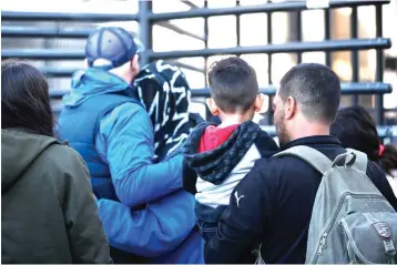  ?? Moises Castillo/Associated Press ?? ■ Honduran asylum seekers enter the U.S. on Wednesday at San Diego’s Otay Mesa port of entry, as seen from Tijuana, Mexico. A federal judge has blocked restrictiv­e Trump administra­tion policies that prevented some immigrants from seeking asylum due to domestic and gang violence in their home countries.