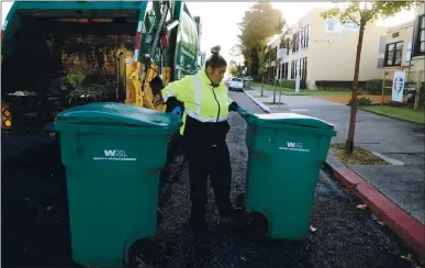  ?? ARIC CRABB — STAFF PHOTOGRAPH­ER ?? Waste Management apprentice driver Lily Nguyen works along her route Oct. 20 in Alameda.Nguyen earned her high school diploma through the Civicorps program in Oakland while gaining job training that led to an apprentice­ship with Waste Management.