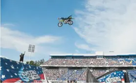  ?? PAUL W. GILLESPIE/CAPITAL GAZETTE ?? A freestyle motocross rider performs a midair lay back trick during the Nitro Circus show held at Navy-Marine Corps Memorial Stadium in 2017.