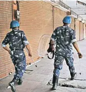  ??  ?? Rapid Action Force personnel walk past closed shops at wall city during 'Bharat bandh' over Scheduled Castes/scheduled Tribes reservatio­n issue, in Jaipur on Tuesday