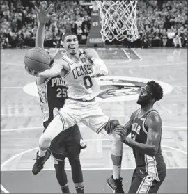  ?? Charles Krupa Associated Press ?? JAYSON TATUM, who scored 25 points, drives between Joel Embiid, right, and Ben Simmons during the second half of the Celtics’ victory.