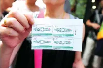  ??  ?? TOP EVENT: Woman shows commemorat­ive stamps marking the G20 Summit in Hangzhou. (AFP)