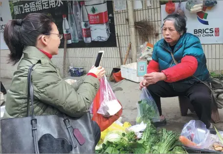  ?? PROVIDED TO CHINA DAILY ?? A customer scans a QR code to pay for goods at Chen Zhuying’s vegetable stall in Nanping, Fujian province.