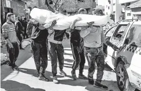  ?? — Gambar AFP ?? SYAHID: Sekumpulan lelaki mengusung jenazah mangsa selepas tentera Israel melepaskan tembakan ke arah rakyat Palestin yang menunggu bekalan makanan di Gaza kelmarin.
