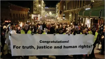  ?? MARKUS SCHREIBER — THE ASSOCIATED PRESS ?? People participat­e in a torchlight procession in honor of the Nobel Peace Prize laureates in Oslo, Norway, on Saturday.