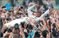  ?? FRANK AUGSTEIN / AP ?? Mercedes driver Lewis Hamilton is carried by fans after winning the British Formula One Grand Prix at Silverston­e, England, on Sunday.