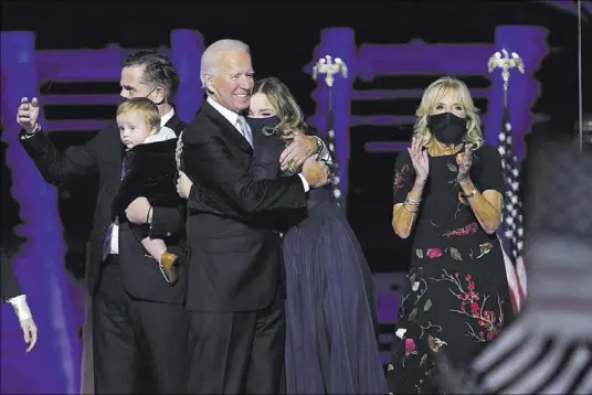  ?? Andrew Harnik The Associated Press ?? President-elect Joe Biden, with his wife, Jill Biden, right, and members of his family take the stage Saturday in Wilmington, Del. “We have to stop treating our opponents like our enemies,” the former vice president said in a speech.