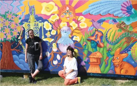  ?? The Sentinel-Record/Tanner Newton ?? Erin Holliday, left, executive director of Emergent Arts, and artist Danaé Brissonnet are shown in front of a new mural Brissonnet helped a group of local teens paint at David F. Watkins Memorial Park, 811 Park Ave.