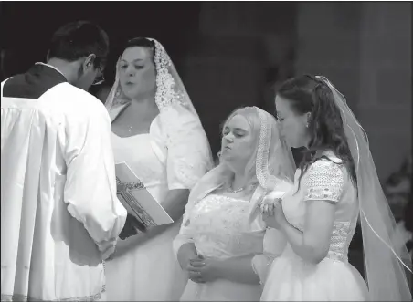  ?? Detroit Free Press (TNS)/KIRTHMON F. DOZIER ?? Laurie Malashanko (left), Theresa Jordan and Karen Ervin sing during a portion of the Consecrati­on of Virgins Living in the World ceremony at the Cathedral of the Most Blessed Sacrament in June. The three women became the first consecrate­d virgins in...