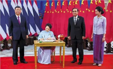  ?? —AFP ?? Ties that bind:
Xi looking on as his wife signs the guestbook during a meeting with Prayut and his wife on the sidelines of apec summit in bangkok.