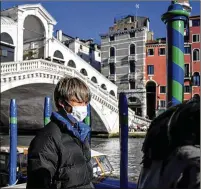  ?? CLAUDIO FURLAN / LAPRESSE ?? ITALY: A pedestrian passes the Ponte di Rialto in Venice on Friday. Authoritie­s in Italy decided to reopen schools and museums in some areas less hard-hit by coronaviru­s in the nation with the most cases outside Asia.