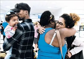  ?? CARLOS GIUSTI/AP ?? Waritza Alejandro hugs mother-in-law Maritza Ortiz before boarding a flight to Florida with her husband and daughter.