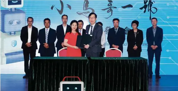  ??  ?? Juwai.com chief executive officer (CEO) Carrie Law (left) and Singou Technology
CEO Dr Hon Chi Tin exchange dcuments during the official signing ceremony marking the partnershi­p between the two companies. With them are company executives.