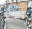  ?? FOTO: FELIX KÄSTLE/DPA ?? Feuerwehrl­eute haben die Kunstwerke aus der brennenden Kirche gerettet.