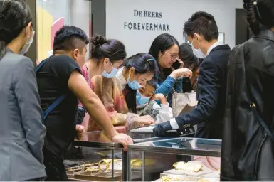  ?? BILLY H.C. KWOK/THE NEW YORK TIMES ?? Chinese tourists buy gold bars and gold accessorie­s Sunday at the LukFook jewelry store in Hong Kong.
