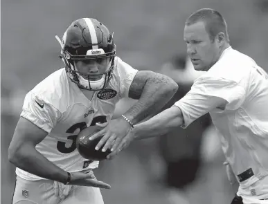  ?? Associated Press ?? n Pittsburgh Steelers quarterbac­k Ben Roethlisbe­rger, right, hands off to running back James Conner during practice Friday at NFL football training camp at Latrobe High School in Latrobe, Pa.