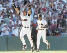  ?? Fred Larson / The Chronicle 1997 ?? The Giants’ Brian Johnson is followed by coach Sonny Jackson after his walkoff homer against the Dodgers on Sept. 18, 1997.