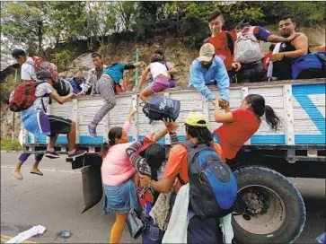  ?? Esteban Biba EPA/Shuttersto­ck ?? HONDURAN immigrants in Zacapa, Guatemala, get on a truck to Guatemala City. President Trump called on several Latin American nations to stop the northward-bound caravan of an estimated 2,000 migrants.