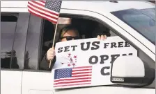  ?? Mark Lennihan / Associated Press ?? A passenger in a car participat­es in a rally during the coronaviru­s pandemic on April 20 in Hartford.