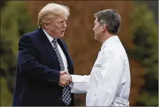  ?? CAROLYN KASTER /AP ?? President Donald Trump shakes hands with White House physician Navy Rear Adm. Ronny Jackson as he boards Marine One to leave Walter Reed National Military Medical Center in Bethesda, Md., Friday.