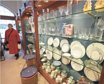  ?? MIKE DE SISTI / MILWAUKEE JOURNAL SENTINEL ?? A woman walks through George Watts & Son last week. The store is closing on Saturday along with the Watts Tea Shop, as the 147-year-old china, flatware and crystal retailer moves fully online.