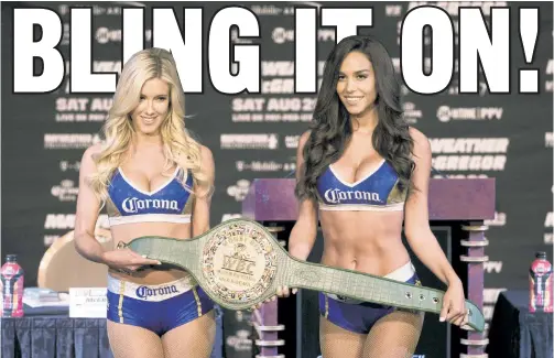  ?? Anthony J. Causi ?? EYES ON THE PRIZE: Two Corona ring card girls display “The Money Belt,” made of solid gold and jewels, which will be presented to the winner of the Conor McGregor-Floyd Mayweather Jr. bout on Saturday night.