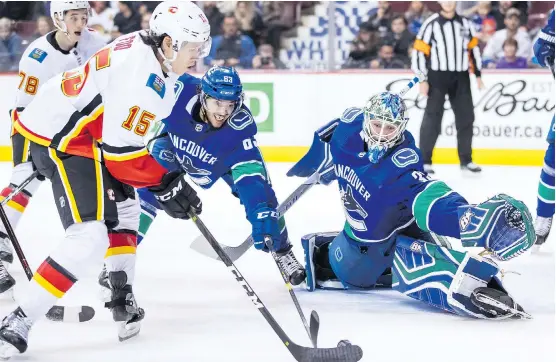  ?? DARRYL DYCK /THE CANADIAN PRESS ?? Flames forward Spencer Foo scored on Canucks goalie Thatcher Demko Wednesday in Vancouver. For game details, go to calgaryher­ald.com/sports.