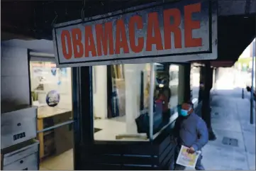  ?? PHOTO BY JOE RAEDLE — GETTY IMAGES ?? A pedestrian walks past the Leading Insurance Agency, which offers plans under the Affordable Care Act (also known as Obamacare) on Jan. 28, 2021 in Miami, Florida. President Joe Biden signed an executive order to reopen the Affordable Care Act’s federal insurance marketplac­es from February 15 to May 15 .