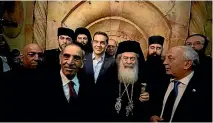  ??  ?? Greek Prime Minister Alexis Tsipras, centre, and and Greek Orthodox Patriarch of Jerusalem Metropolit­an Theophilos, center right, walk out following a ceremony marking the end of restoratio­n work on the site of Jesus’s tomb.